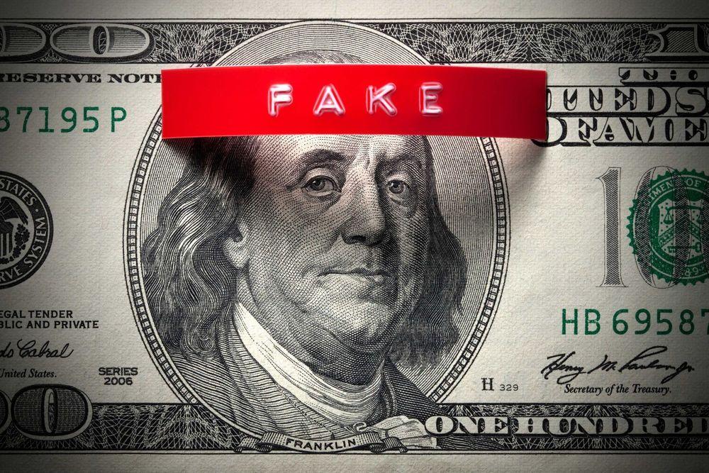 A 100 dollar bill with a tag that says fake on it